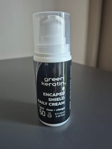 Photo d'un client montrant le nouveau flacon de la crème ENCAPSUSHIELD SPF50.