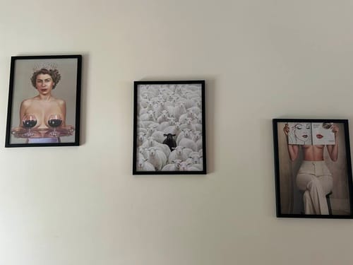 Customer's three Black Oak Gallery Frames hanging on a plain wall, each displaying a unique art print.