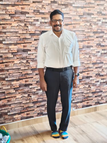 Reviewer standing indoors wearing the regular fit white formal shirt with sleeves rolled up.