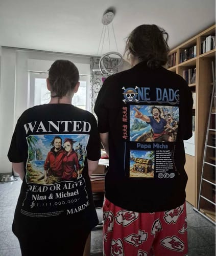 Zwei Rezensenten von hinten in personalisierten schwarzen T-Shirts, eines mit dem 'ONE DAD'-Aufdruck.