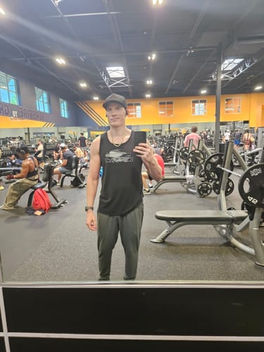 Customer wearing the black 80Eighty® Limited Edition DCG89 Tank in a mirror selfie at the gym.