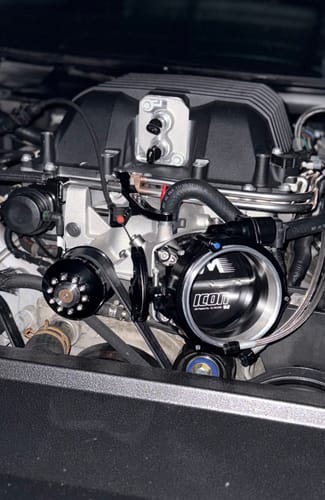 Customer's black ICON throttle body installed in a clean car engine bay.