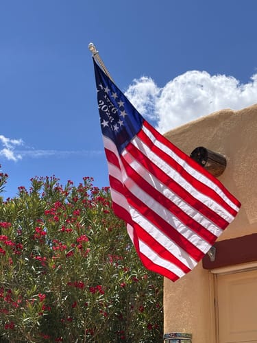 Customer's 1776 to 2026 Betsy Ross Flag flying on a flagpole outside a home, showing the embroidered stars and dates.