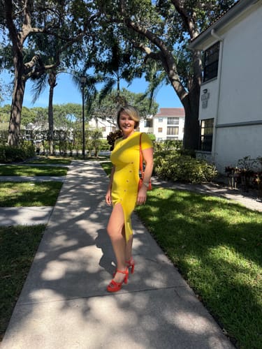 Customer posing outdoors in the yellow Keyara dress, showing the button detail and side slit.