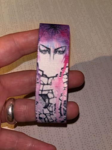 Customer's hand holding the I Ask For So Little Labyrinth Bracelet, showing the colorful Jareth design.