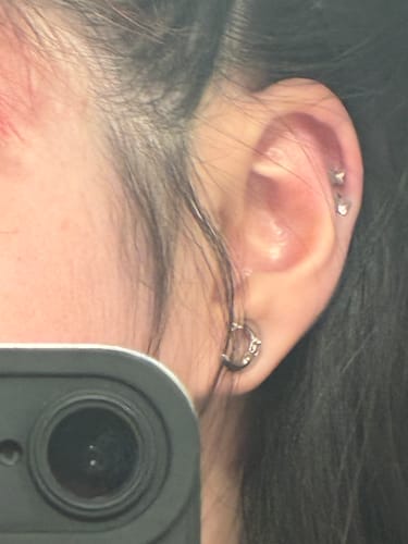 Close-up of a reviewer's ear showing the silver Luna the Lunatic Lunar Earring in a fresh helix piercing.
