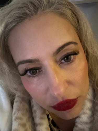 A reviewer's close-up showing her full Infinaluxe lash extensions after application.