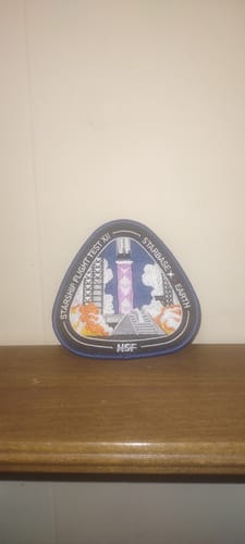 Customer's embroidered Starship Flight 12 Collectors Patch resting on a wooden shelf.