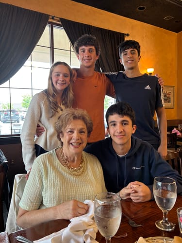 Customer's photo of a smiling group of five people at a restaurant.