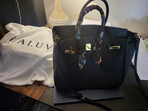 Customer's black LALUVA Warkin Bag on a desk with its white dust cover and a scarf tied to the handle.