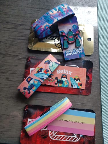 Customer's items from a Mystery 3-Pack: three wristbands, their collector's cards, and one enamel pin.
