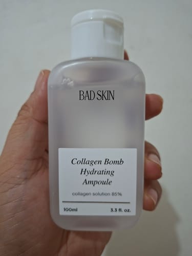 Customer holding a bottle of Bad Skin Collagen Bomb Hydrating Ampoule in their hand.