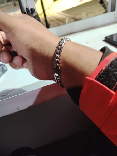 Un cliente muestra la Pulsera Cuban de 8mm en su muñeca, que se ve brillante y resistente.