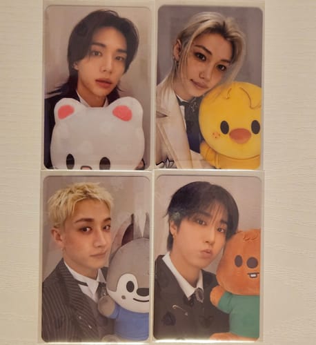 Customer's four STRAY KIDS photocards from the Skzoo pop-up event, showing the members holding character plushies.