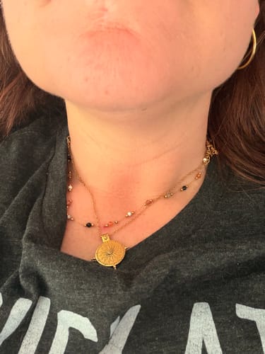 Close-up of a customer wearing the Summer Solstice Gold Necklace layered with another beaded necklace.