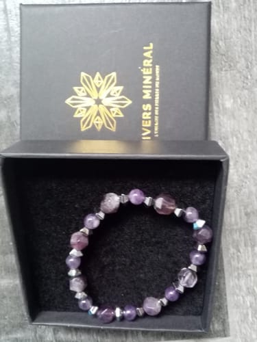 Photo d'un client montrant le bracelet Améthyste dans son écrin noir.