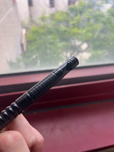 Close-up of a reviewer's hand holding the black 80Eighty MultiTool Whistle.