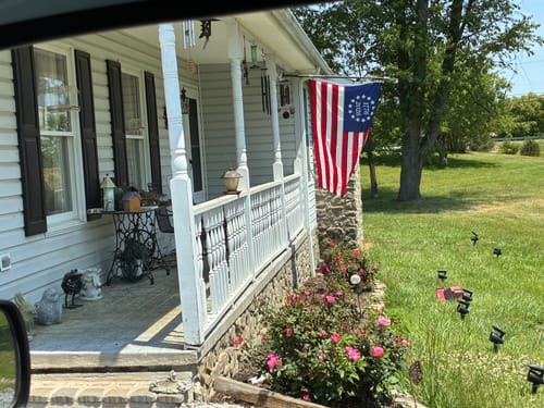 Customer's Betsy Ross Flag displayed on the front porch of their home.