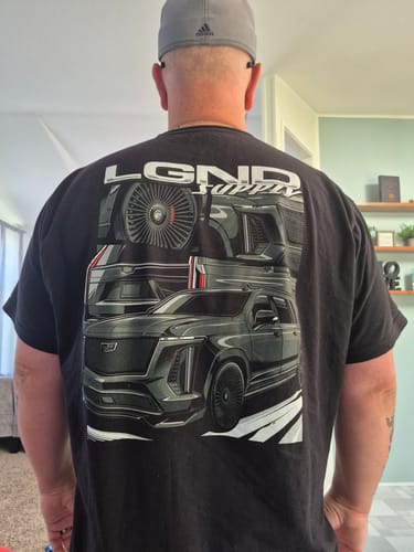 Customer from behind wearing a black t-shirt from the LGND93 Mystery Box with a large car graphic on the back.