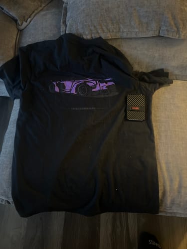 Customer's black 80Eighty DCG88 Shirt with a purple car graphic laid out on a couch.