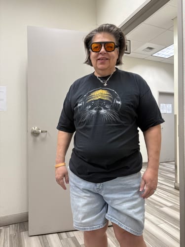A reviewer wearing their black Otter Tune - Premium t-shirt paired with orange-tinted glasses.