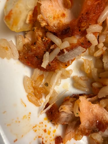 Reviewer's close-up photo of a small bone in the Fit Salmon meal with rice.