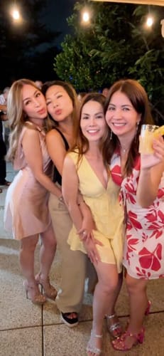 Customer posing with friends at an evening event, wearing the floral Lunavie Mini Dress.