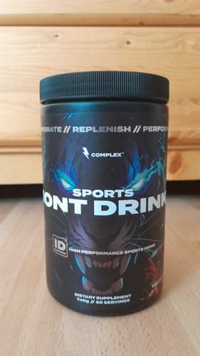 Customer's black tub of Dual-Carb Ion Drink with a bold tiger graphic, sitting on a wood surface.