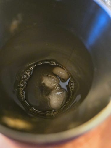 Client montrant sa boisson IsoGen Café Glacé mélangée avec des glaçons dans un shaker.