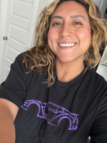 Reviewer smiling while wearing the black 80Eighty® DCG88 Shirt with a purple car graphic.