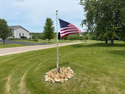 Customer's Ultra Heavy Duty American Flag waving on a flagpole in a grassy yard.