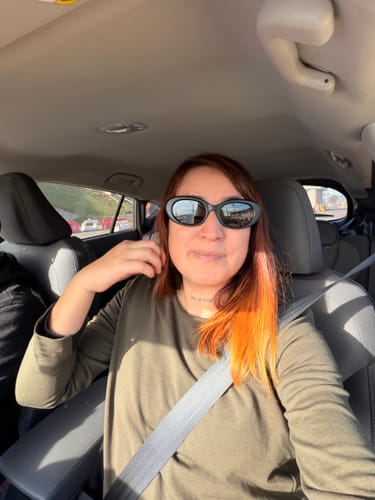Una clienta en un coche muestra su pelo con un intenso color cobrizo tras usar la Henna Jamila BAQ.