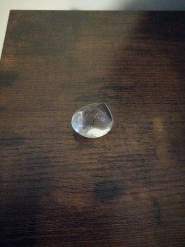 Le Cristal de Roche qualité AAA d'un client, une pierre claire et polie sur une table.