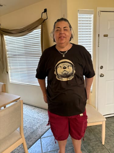 Reviewer standing indoors wearing the dark Otterspace t-shirt with its graphic of an otter in an astronaut helmet.