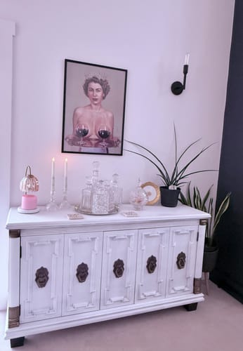 Customer's Black Oak Gallery Frame with an art print, hung on a wall above a white sideboard.