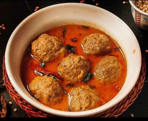 Customer's cooked Kofta Kababs served in a spicy red sauce in a white bowl.