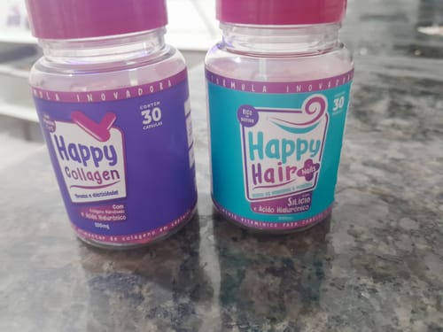 Cliente mostra um pote de Happy Hair e um de Happy Collagen, lado a lado em uma bancada.