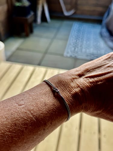 A reviewer wears the simple Forever Knot Bracelet on their wrist.