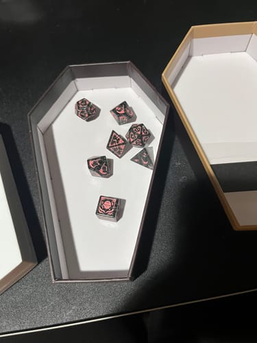 Reviewer's Mori Calliope dice set displayed inside its open, coffin-shaped storage box.
