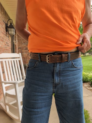 Customer lifting their shirt to show the brown Woodstock Double Prong belt on their jeans.