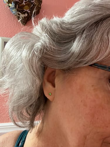 Customer wearing the small green Summer Star Comfort Earring on their earlobe.
