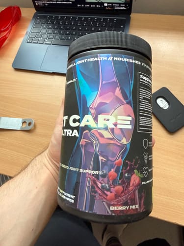 Customer holding the Joint Care Ultra supplement tub in the Berry Mix flavor.
