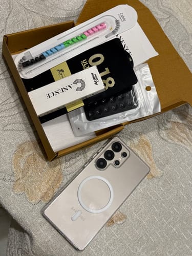 Reviewer unboxes the Anti Yellow Magsafe Clear Case, showing the case on a phone next to its packaging and a cable protector.