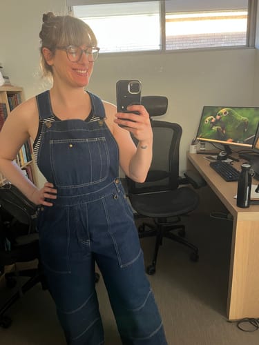 Reviewer in an office showing the fit of their mid-blue Denim Brumby Suit.