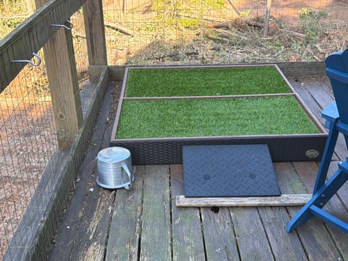 Customer's assembled Porch Potty MEGA with two grass pads on an outdoor wooden deck.