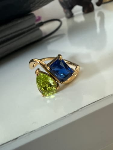 Customer's close-up of the Navae Birthstone Ring with a vibrant green pear-cut and blue radiant-cut stone.