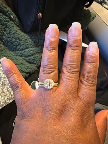 A customer's hand wearing the two-piece Aureline wedding set in a gold finish.