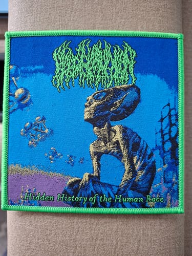 Customer's woven Blood Incantation patch showing the 'Hidden History of the Human Race' art with a vibrant green border.