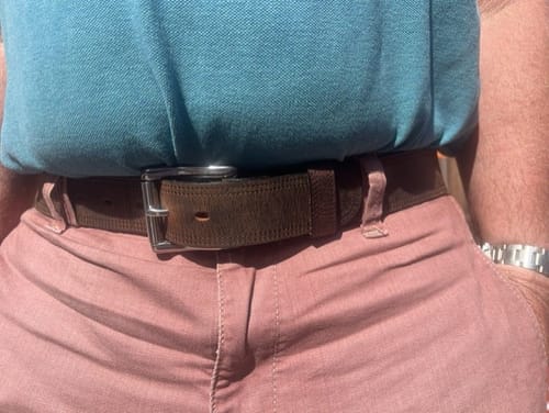 Customer wearing the brown Wyoming Bison belt with pink pants and a blue polo shirt.