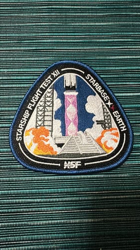 Reviewer's embroidered Starship Flight 12 Collectors Patch on a textured surface.